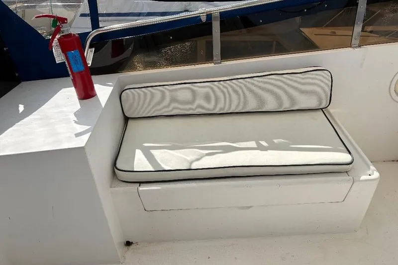 Slide: The Image of White cushioned seat and fire extinguisher on 1990 Hi-Star Trawler boat deck. - 34