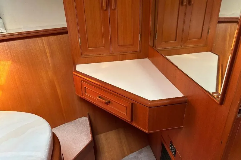 Slide: The Image of 1990 Hi-Star Trawler interior with wooden cabinetry and corner vanity. - 20