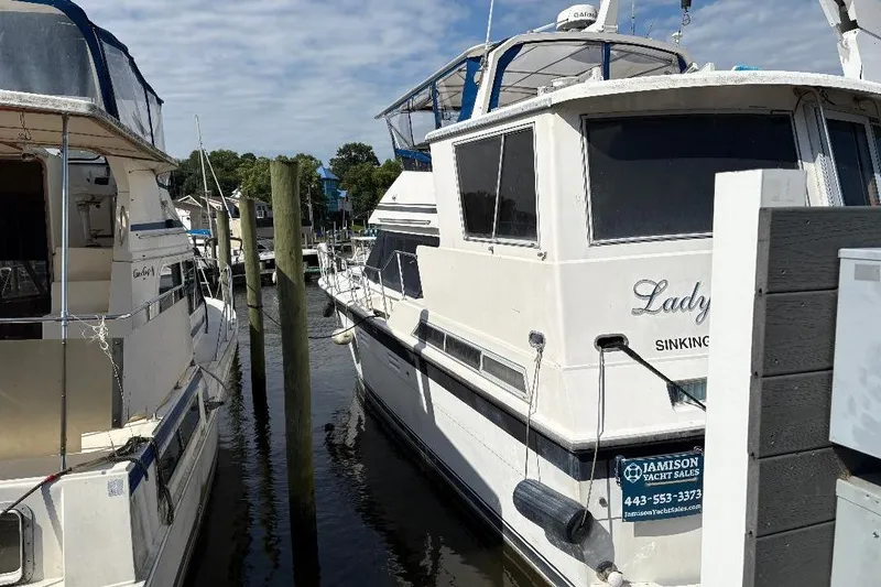 The Image of 1990 Hi-Star Trawler docked at marina, featuring "Lady" name and yacht sales contact. - 1