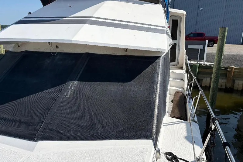 Slide: The Image of 1990 Hi-Star Trawler boat docked, featuring a white exterior and shaded windows. - 4