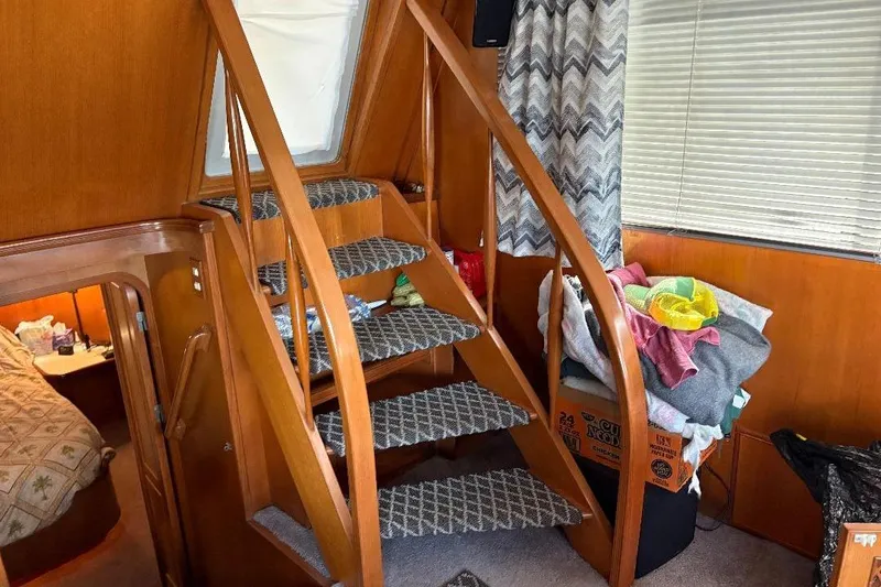 Slide: The Image of Interior of a 1990 Hi-Star Trawler with wooden stairs and cozy cabin decor. - 11