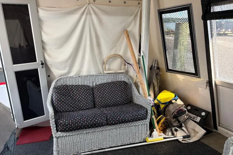 Slide: The Image of Interior of a 1990 Hi-Star Trawler with wicker sofa and cleaning supplies. - 32