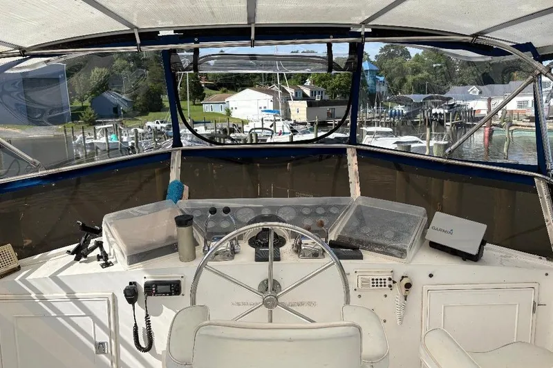 Slide: The Image of 1990 Hi-Star Trawler helm with steering wheel, navigation equipment, and marina view. - 39