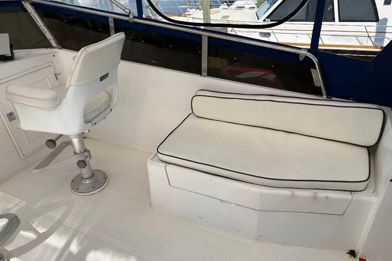 Slide: The Image of Interior of a 1990 Hi-Star Trawler featuring white seating and helm chair. - 33