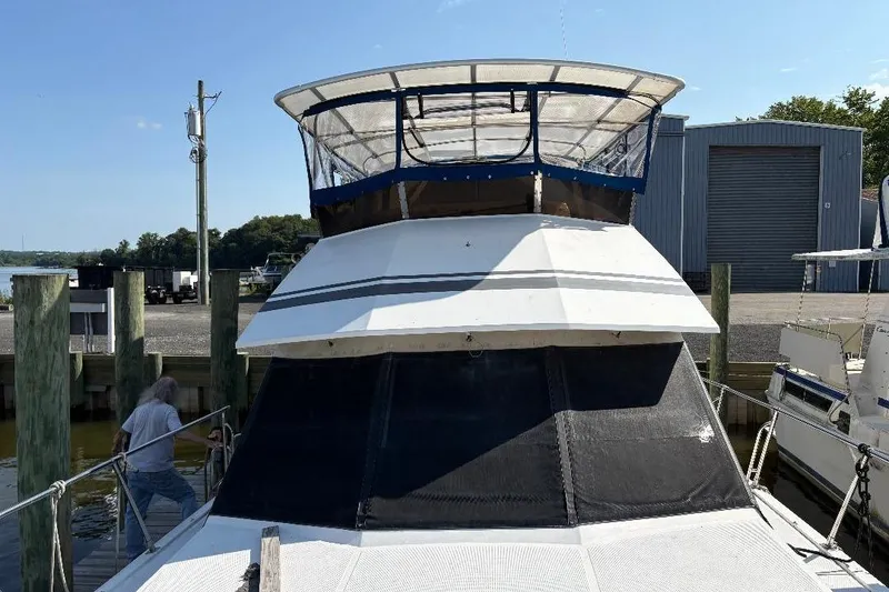 Slide: The Image of 1990 Hi-Star Trawler docked at marina, featuring upper deck and covered helm. - 2