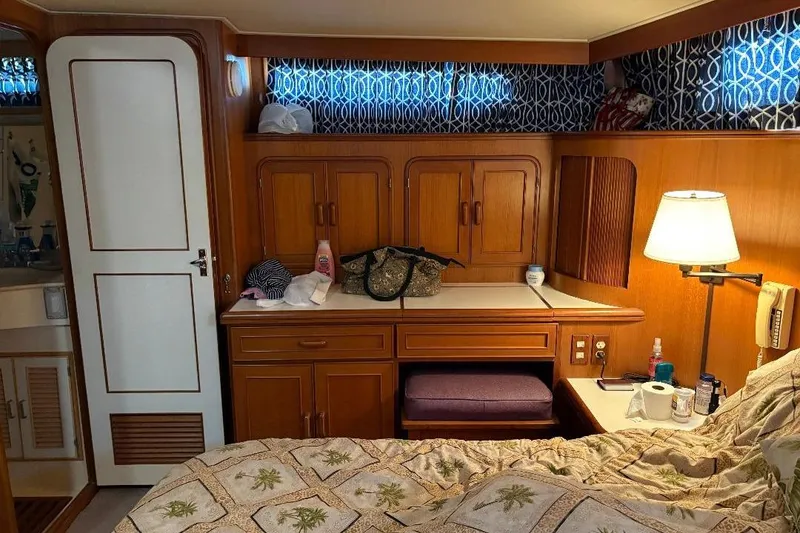 Slide: The Image of Cozy 1990 Hi-Star Trawler cabin interior with wooden cabinetry and patterned bedding. - 29