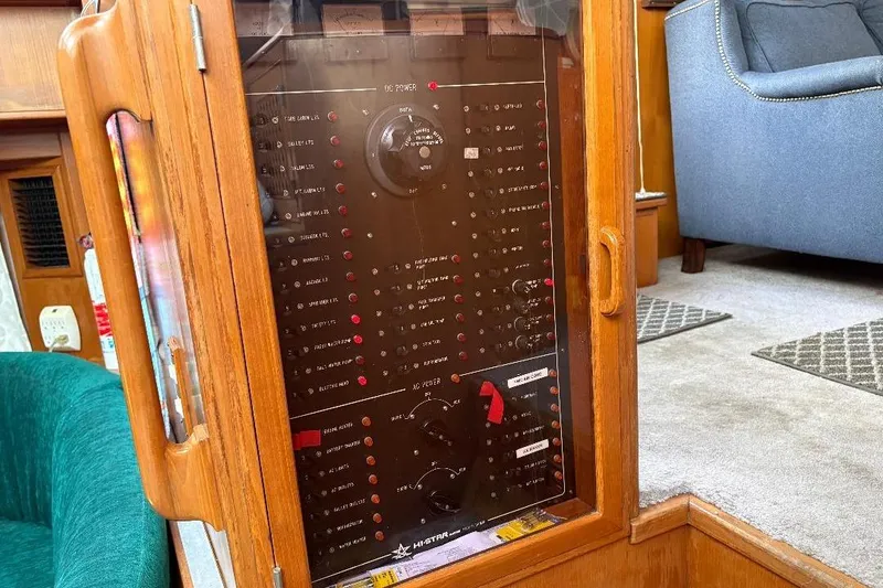 Slide: The Image of Control panel inside a 1990 Hi-Star Trawler, featuring wooden cabinetry and seating area. - 13