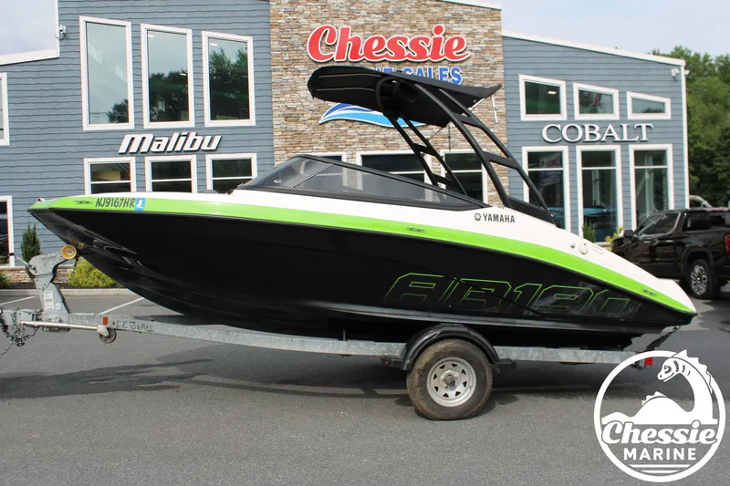 Slide: The Image of A 2022 Yamaha AR190 boat on a trailer in front of a building with signage. - 2
