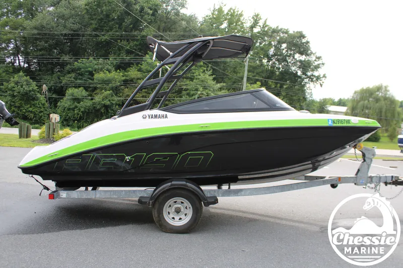 Slide: The Image of A 2022 Yamaha AR190 boat on a trailer, featuring a green stripe and black hull. - 6