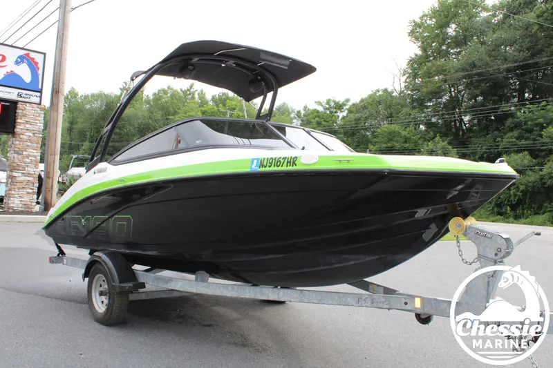 Slide: The Image of A 2022 Yamaha AR190 boat on a trailer, featuring a green stripe and black hull. - 7