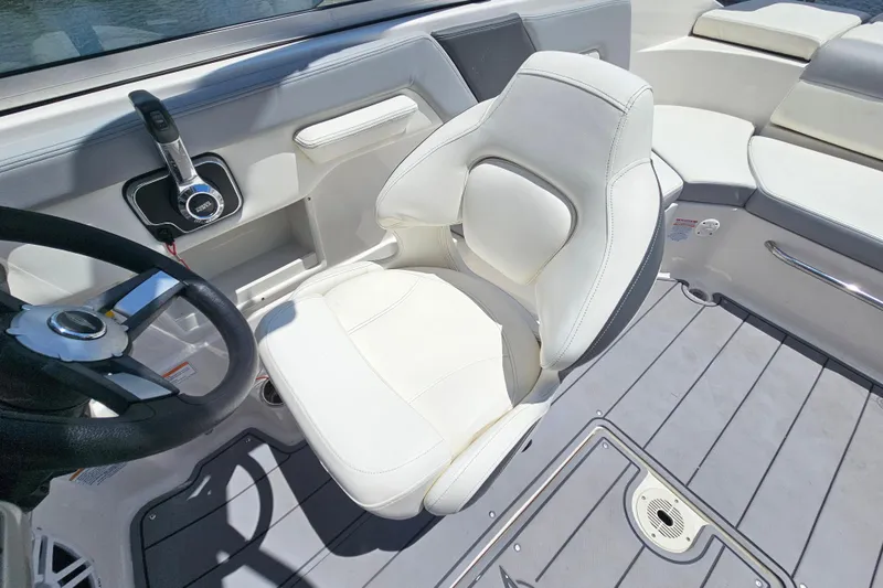 Slide: The Image of 2023 Chaparral 23 SSi boat interior with white captain's chair and steering wheel. - 14