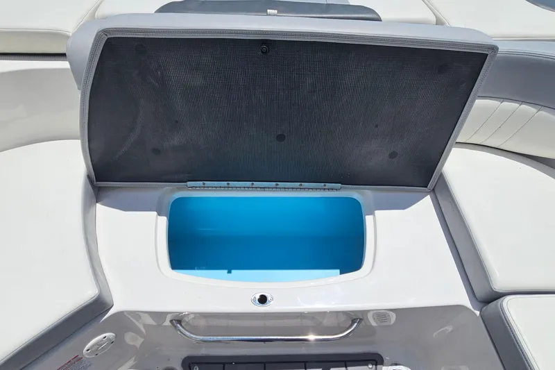 Slide: The Image of Open storage compartment on 2023 Chaparral 23 SSi boat, featuring a blue interior. - 10