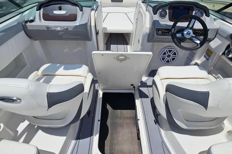 Slide: The Image of 2023 Chaparral 23 SSi boat interior with white seating and modern dashboard. - 16