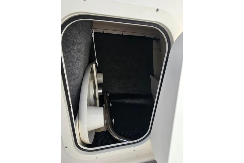Slide: The Image of Storage compartment inside 2023 Chaparral 23 SSi boat, featuring a neatly organized interior. - 19