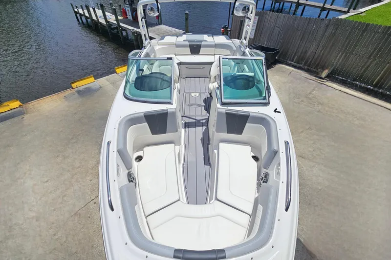 Slide: The Image of 2023 Chaparral 23 SSi boat with spacious seating, docked near water. - 23