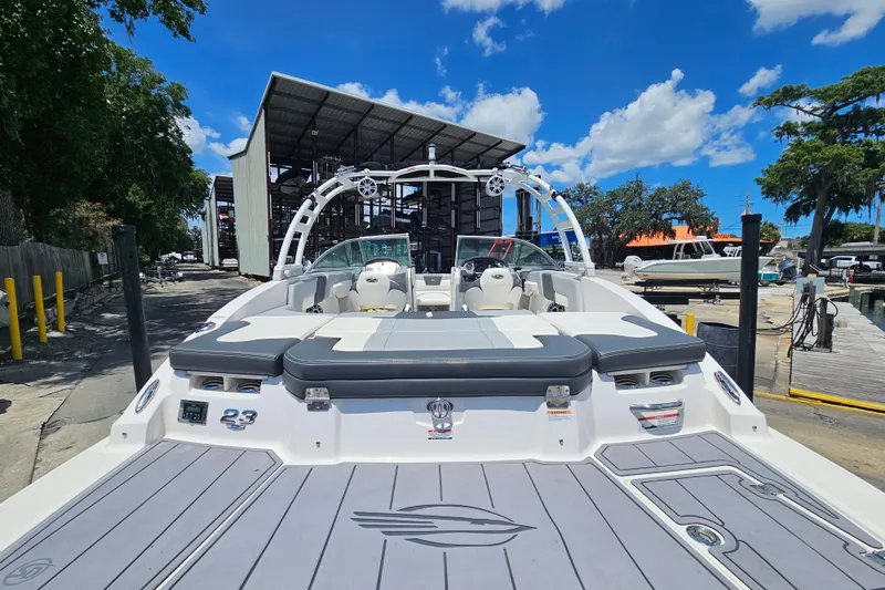 Slide: The Image of 2023 Chaparral 23 SSi boat docked at marina under clear blue sky. - 4