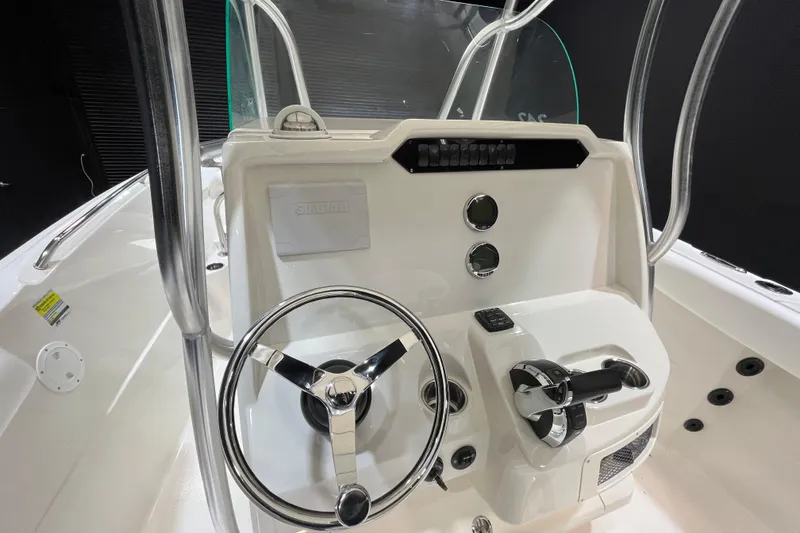 Slide: The Image of 2022 Sailfish 242 CC boat console with steering wheel and controls. - 11