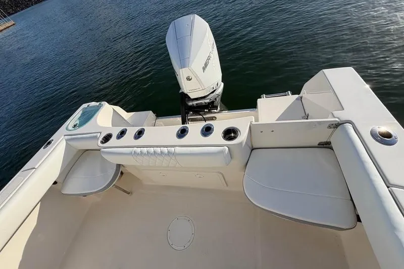 Slide: The Image of 2022 Sailfish 242 CC boat interior with seating and Mercury outboard motor on water. - 7