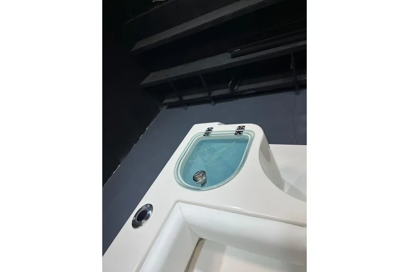 Slide: The Image of 2022 Sailfish 242 CC boat detail with sleek white finish and blue compartment lid. - 16