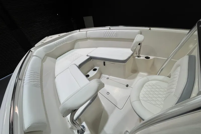 Slide: The Image of 2022 Sailfish 242 CC boat interior with white cushioned seating and sleek design. - 12