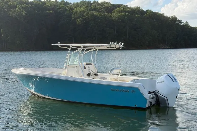 The Image of 2022 Sailfish 242 CC boat on a serene lake with forested background. - 0