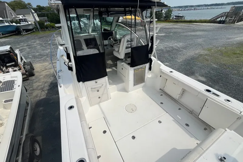 Slide: The Image of 2012 Boston Whaler 285 Conquest boat interior, featuring spacious deck and helm area. - 7
