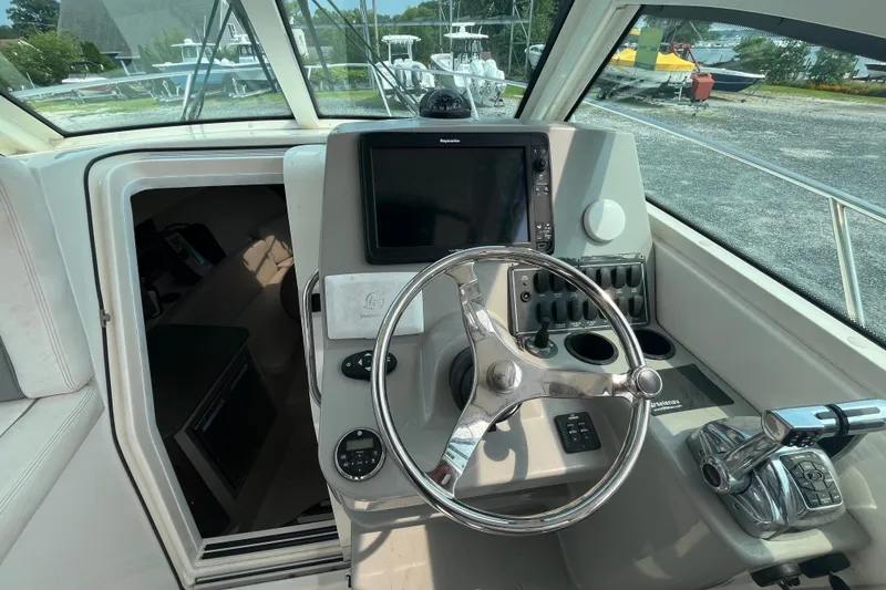 Slide: The Image of Helm of 2012 Boston Whaler 285 Conquest with steering wheel and navigation controls. - 14