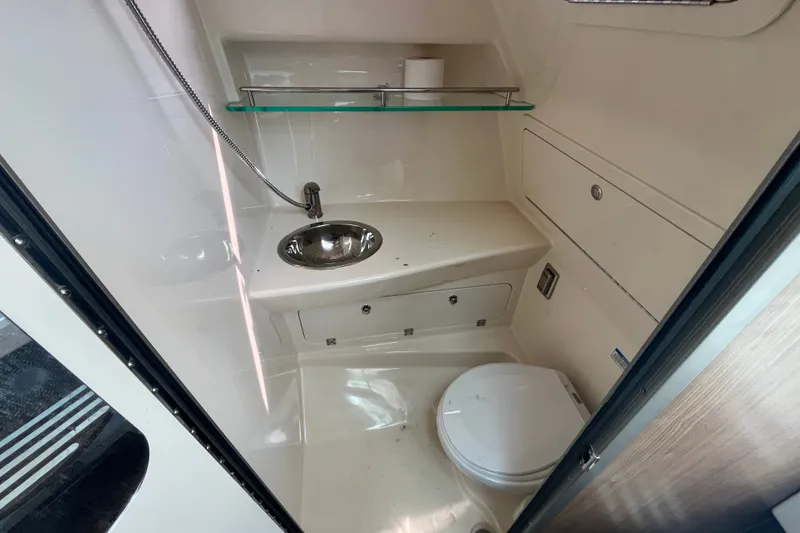 Slide: The Image of 2012 Boston Whaler 285 Conquest bathroom with sink, toilet, and storage. - 6