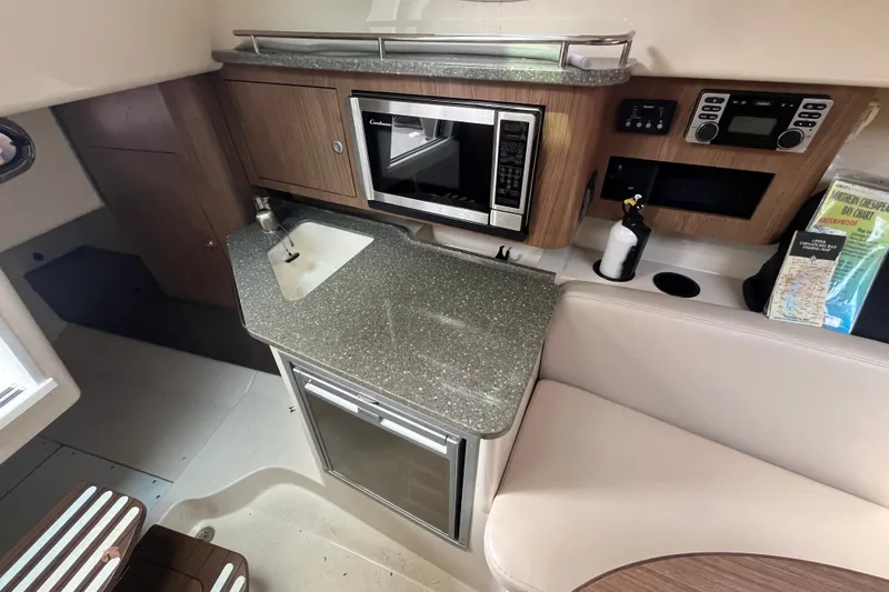 Slide: The Image of 2012 Boston Whaler 285 Conquest cabin interior with kitchenette and seating area. - 4