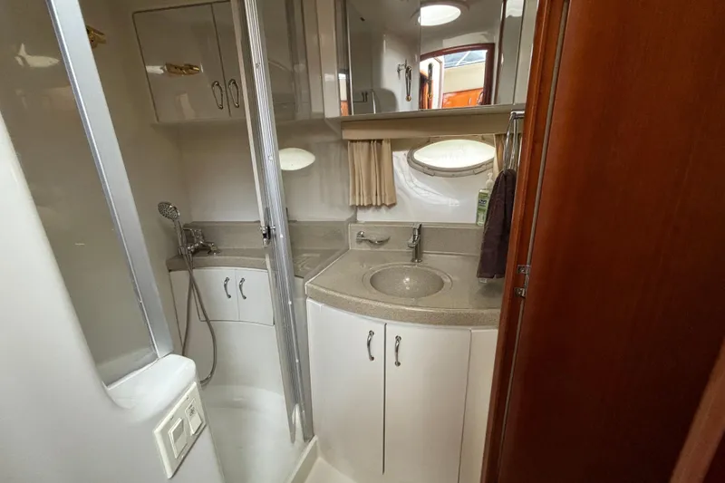 Slide: The Image of 2004 Carver 360 Sport Sedan bathroom with shower, sink, and storage cabinets. - 16