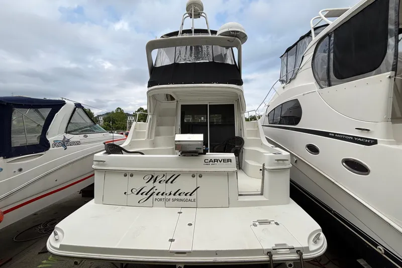 Slide: The Image of 2004 Carver 360 Sport Sedan yacht docked, rear view with "Well Adjusted" name visible. - 3