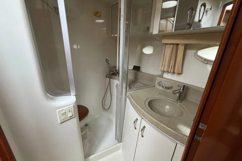 Slide: The Image of 2004 Carver 360 Sport Sedan bathroom with shower, sink, and storage cabinets. - 15