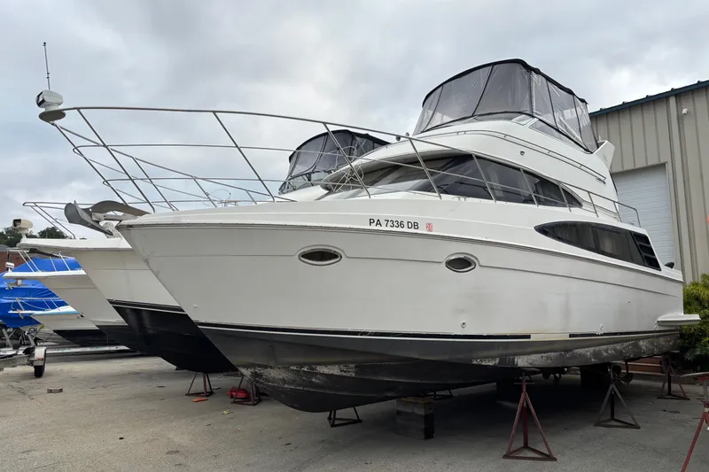 The Image of 2004 Carver 360 Sport Sedan yacht on stands, ready for maintenance at a marina. - 1