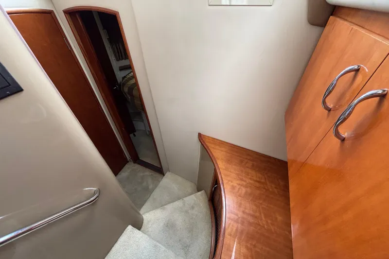Slide: The Image of Interior of 2004 Carver 360 Sport Sedan, featuring wooden cabinetry and carpeted stairs. - 12