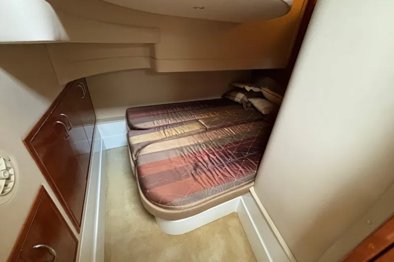 Slide: The Image of 2004 Carver 360 Sport Sedan cabin with cozy twin beds and wooden cabinetry. - 13