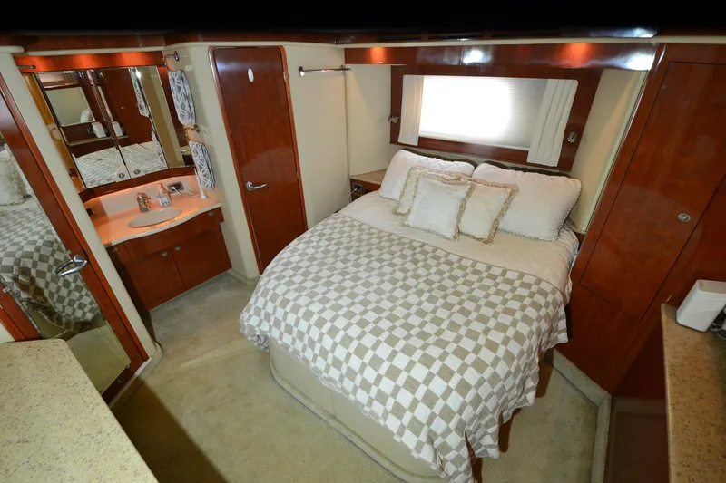 Slide: The Image of Luxurious 2004 Sea Ray 480 Motor Yacht bedroom with elegant wood finishes and cozy bedding. - 22