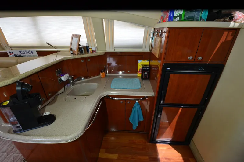 Slide: The Image of 2004 Sea Ray 480 Motor Yacht kitchen with wooden cabinets, sink, and appliances. - 20