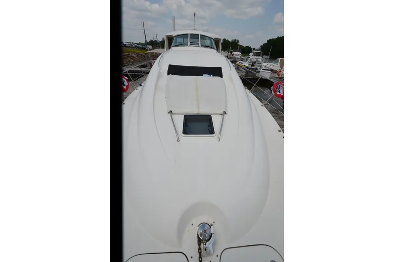 Slide: The Image of 2004 Sea Ray 480 Motor Yacht, docked, showcasing sleek white deck design. - 12