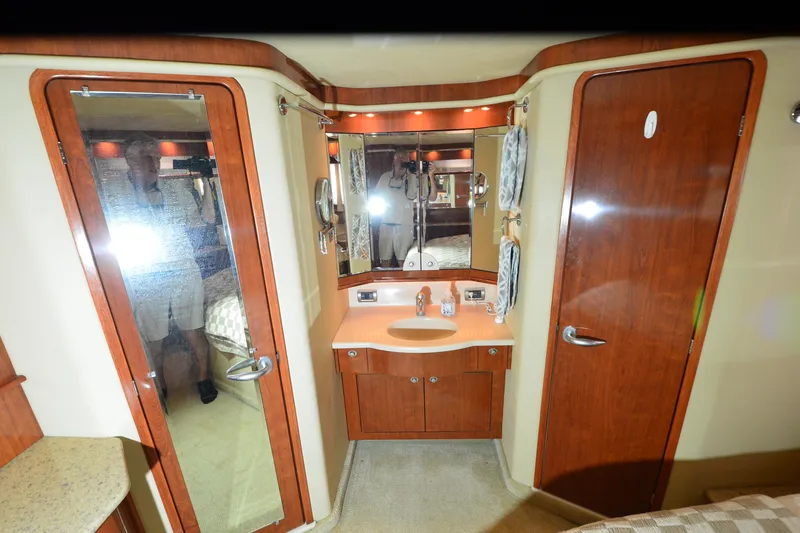 Slide: The Image of Luxurious bathroom interior of 2004 Sea Ray 480 Motor Yacht with wood accents and mirrored cabinets. - 24