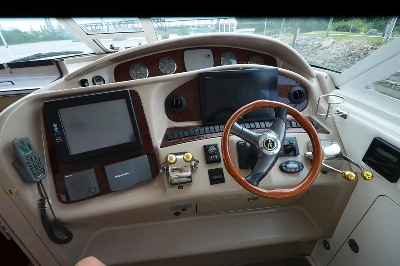 Slide: The Image of Control panel of a 2004 Sea Ray 480 Motor Yacht with steering wheel and navigation equipment. - 14