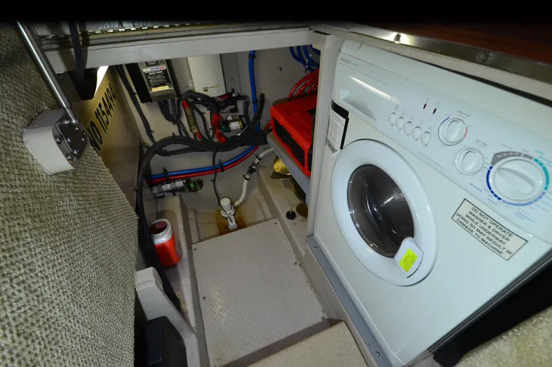 Slide: The Image of Laundry area inside 2004 Sea Ray 480 Motor Yacht, featuring a washing machine and utility space. - 42