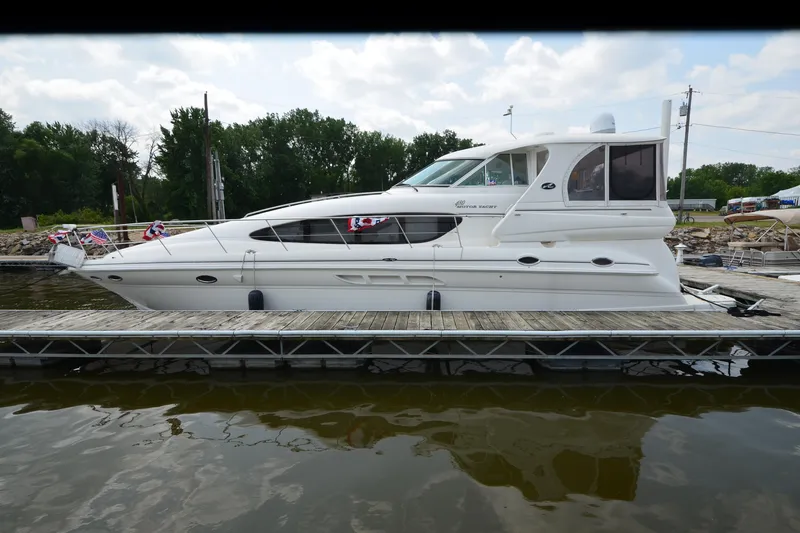 Slide: The Image of 2004 Sea Ray 480 Motor Yacht docked on a calm lake with trees in the background. - 6
