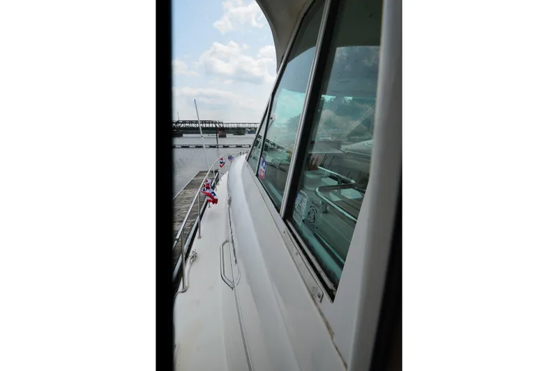 Slide: The Image of 2004 Sea Ray 480 Motor Yacht docked, side view with windows and railing. - 10