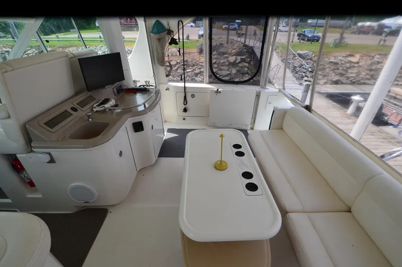 Slide: The Image of Interior of 2004 Sea Ray 480 Motor Yacht with seating, table, and control panel. - 15