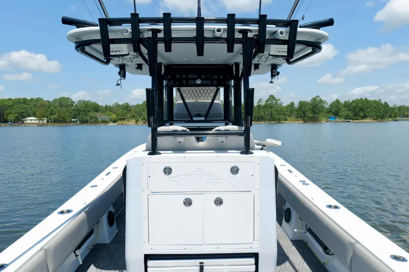 Slide: The Image of 2023 Andros 32 Offshore boat on calm lake with clear sky and lush shoreline. - 24