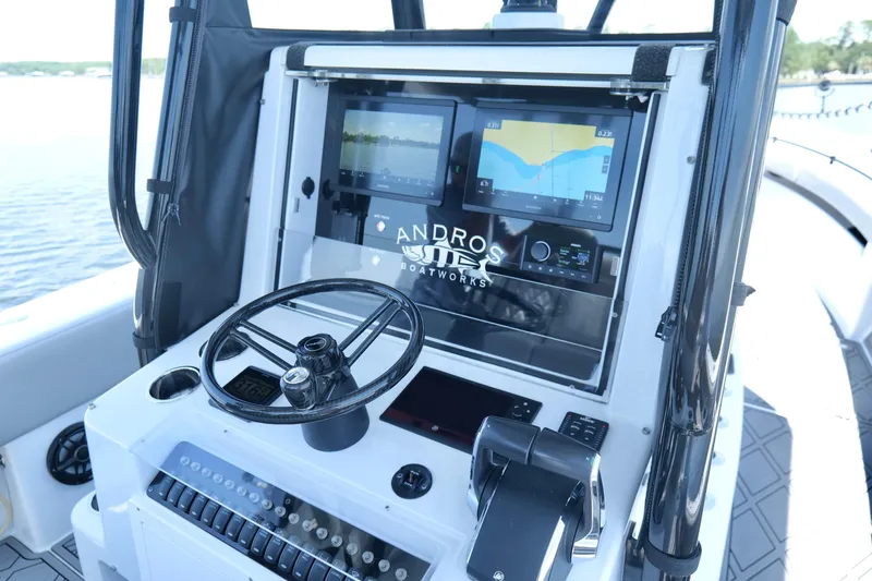 Slide: The Image of 2023 Andros 32 Offshore boat dashboard with navigation screens and steering wheel. - 11