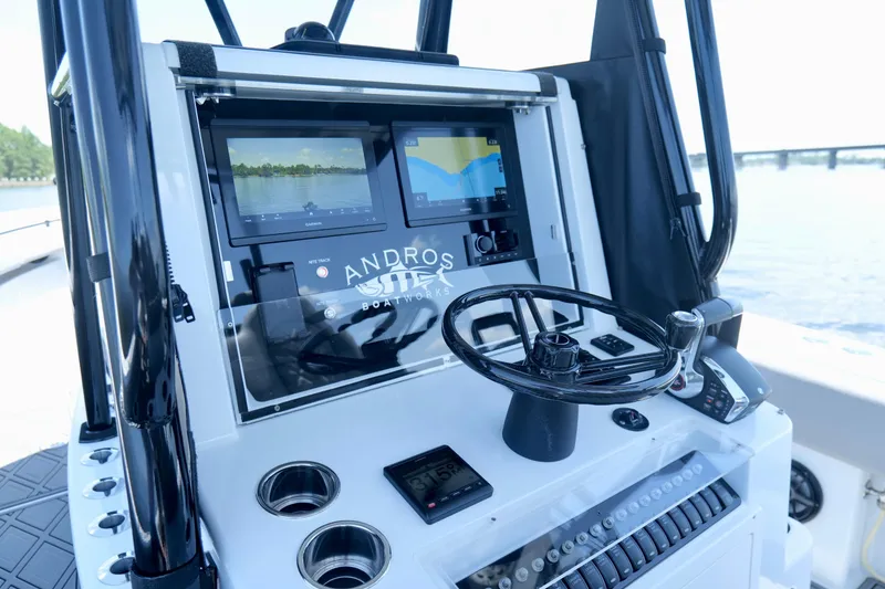 Slide: The Image of 2023 Andros 32 Offshore boat dashboard with navigation screens and steering wheel. - 10