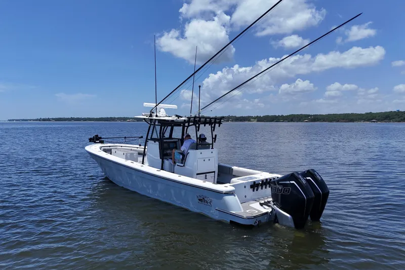 Slide: The Image of 2023 Andros 32 Offshore boat on calm water with clear blue sky. - 2