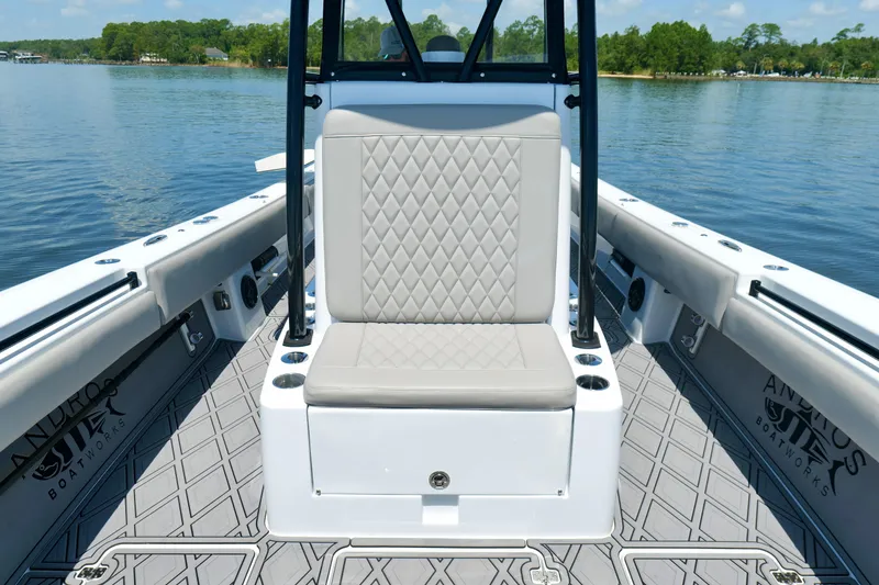 Slide: The Image of 2023 Andros 32 Offshore boat interior with cushioned seating and diamond-patterned flooring. - 34