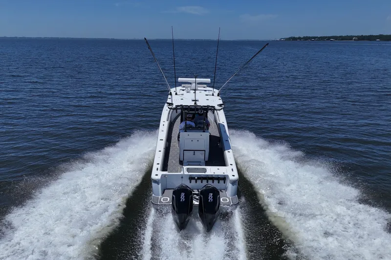 Slide: The Image of 2023 Andros 32 Offshore boat cruising on open water, rear view. - 7